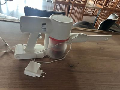 un mixeur blanc et rouge posé sur une table en bois
