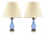 paire de lampes de table en verre bleu avec des pieds et des abat-jours en laiton