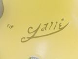 a yellow vase with a picture of a woman on it