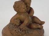 a small statue of a boy and a baby on a plate