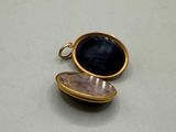 a small gold locke with a black stone in it
