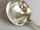 a silver spoon with a metal handle on a table