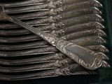 a lot of silver spoons and forks in a green case