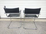 pair of chrome and black leather chairs in front of a garage door