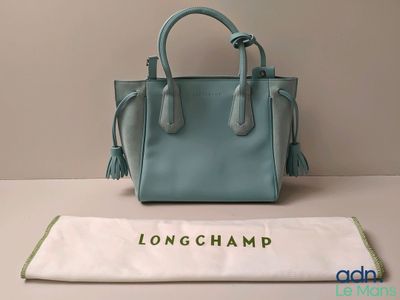Le sac à main Longchamp est posé sur une table, à côté d'un autre sac.