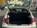 the back of a white car with its trunk open in a parking lot