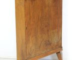 a wooden grandfather clock on a stand against a white wall