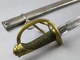 a close up of a sword on a white surface