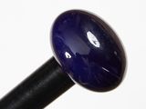 un gros plan d'une boule de verre bleue fixée à un bâton noir