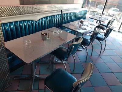 a table and chairs in a restaurant with a blue booth