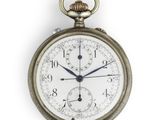 une montre de poche en argent posée sur une surface blanche, sur fond blanc