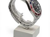 a watch that is sitting on a stand on a white surface