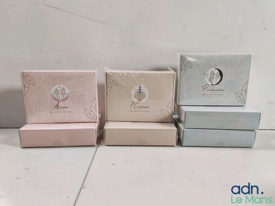 trois boîtes de savon empilées les unes sur les autres sur une table