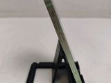 a silver cell phone sitting on top of a black stand