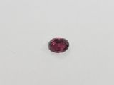 a red garnet stone on a white surface
