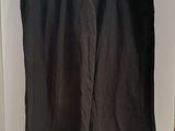 black pants hanging on a hanger in a white room