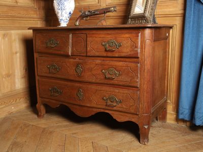 une commode en bois sur laquelle est posé un vase bleu et blanc