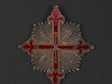 a close up of a red and gold cross on a black background