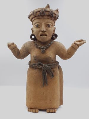 statue d'une femme portant une couronne sur la tête et les mains levées