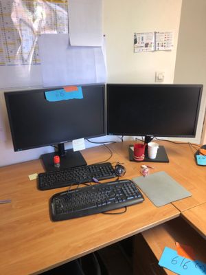 a desk with two computer monitors and a keyboard on it