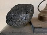 a rock sitting on top of a stove next to a lamp