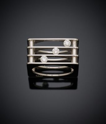 une bague en or blanc sertie de trois diamants sur fond noir