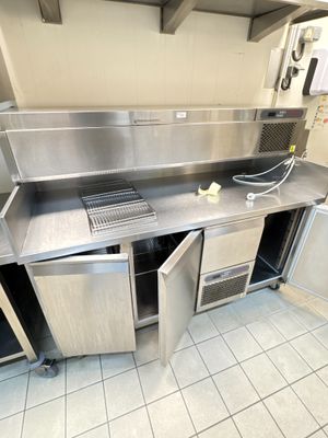 une grande cuisine en inox équipée d'un évier et d'un réfrigérateur