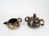 pair of silver and black ceramic teapots on white background