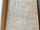 un vieux journal posé sur une table, à côté d'une tasse de café