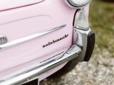 a close up of a pink car parked on the side of the road