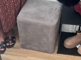 a woman that is standing next to a stool with shoes on it