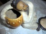 une figurine représentant un homme tenant une tasse posée sur une table