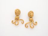 an image of a pair of gold octopus earrings on a white surface