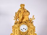 une horloge en or surmontée d'une statue