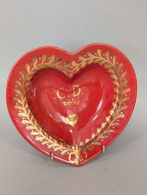 petit plat rouge en forme de cœur, orné de feuilles d'or et portant l'inscription « Je t'aime »