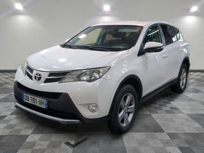 La Toyota RAV blanche est garée sur un sol en carrelage à damier.