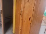 a wooden cabinet in the middle of a room that is being remodeled