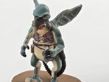 figurine of a dragon with a human body on a wooden base