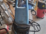 un aspirateur bleu posé par terre à côté d'un tas de bric-à-brac
