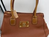 a brown purse with a tag on it sitting on a table
