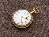 une montre de poche en or avec des chiffres romains