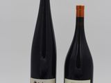 deux bouteilles de vin posées l'une à côté de l'autre sur une surface blanche