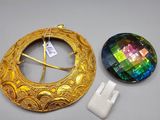 two pieces of jewelry are sitting on a table next to each other