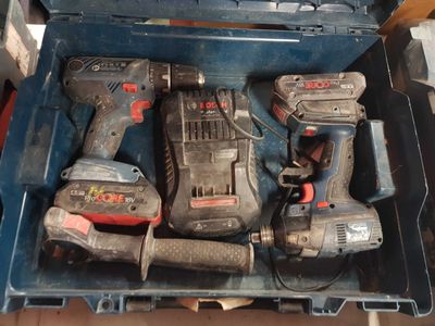 deux outils électriques dans une boîte à outils posée par terre