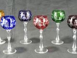 six verres à vin sont alignés sur une table