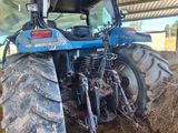 a blue tractor that is parked in a barn