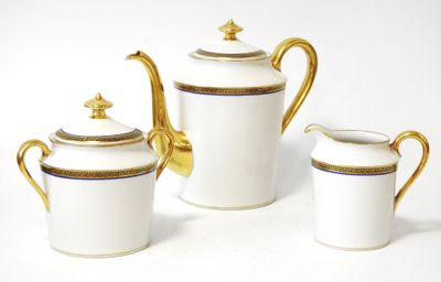 three pieces of white and gold tea set on a white surface