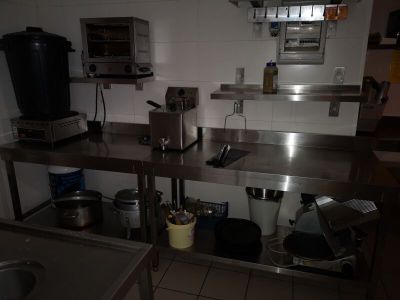une cuisine avec des plans de travail en inox et un évier