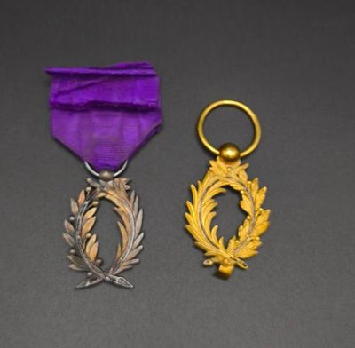 purple ribbon with a gold wreath on it and a purple ribbon with a gold wreath on it
