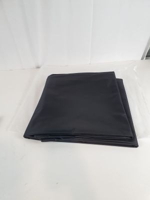 un gros plan d'un tissu noir plié posé sur une surface blanche